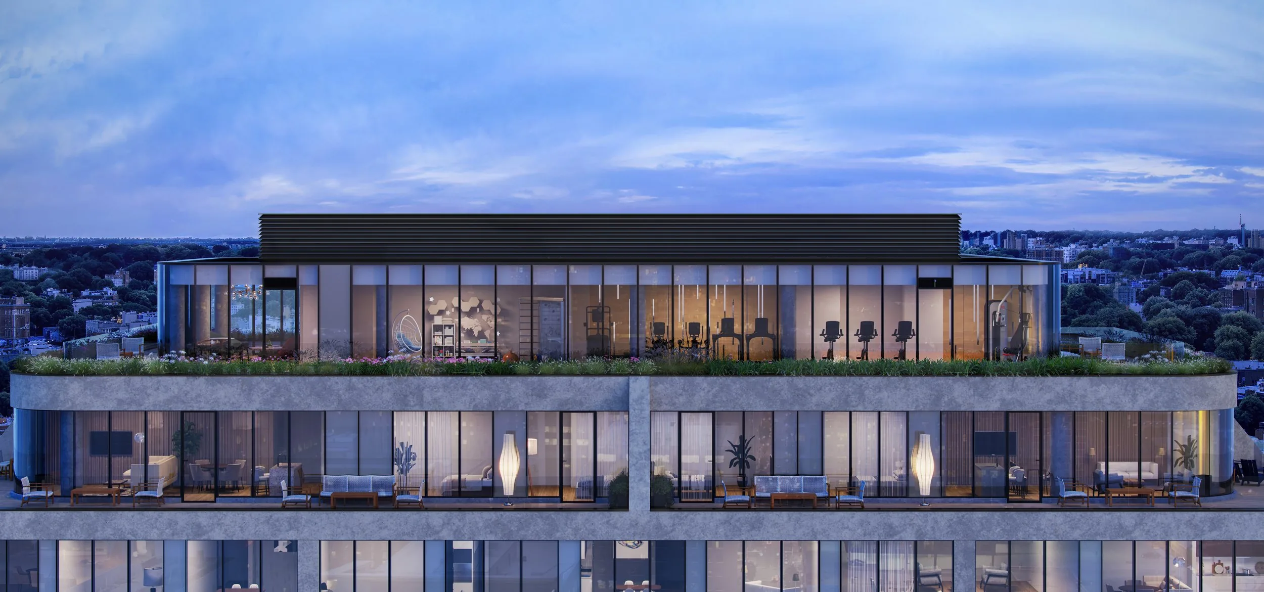 The rooftop amenity crown at dusk, gym and lounge lit within