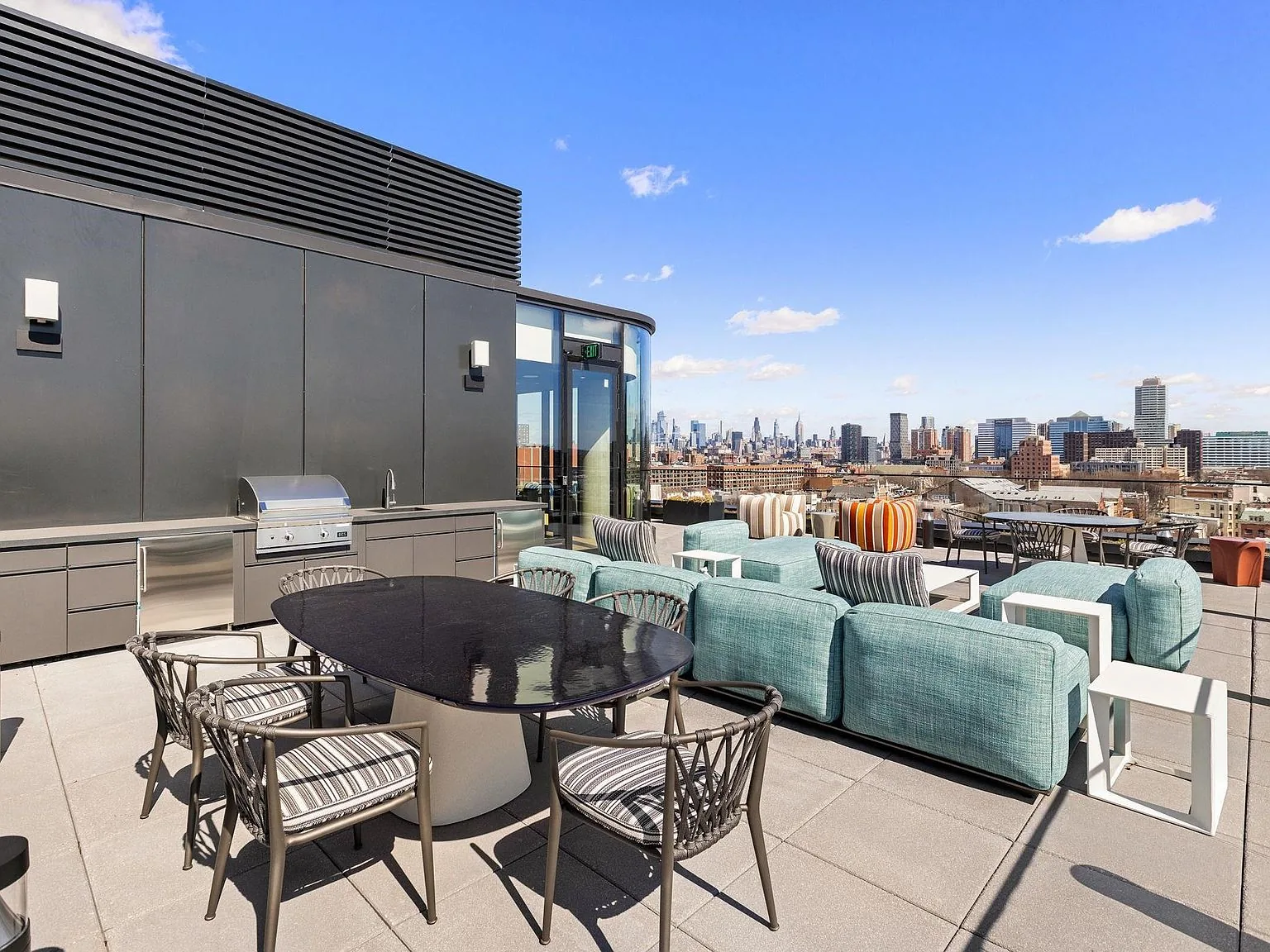 The rooftop terrace as built, dining tables facing the Downtown and Manhattan skyline
